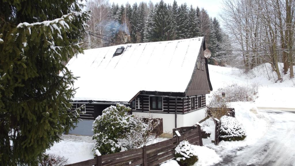 a house covered in snow with a roof at Chaloupka za mostem Plavy - Jizerské hory in Plavy