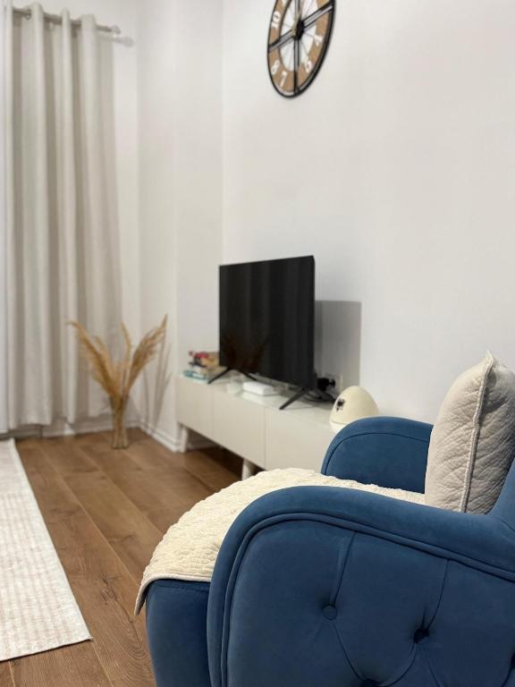 a living room with a blue couch and a tv at Golden Apartment 1 in Kamëz