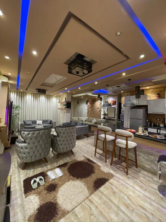 a living room with furniture and a kitchen at شقه فندقيهTv75-PS4حدايق الاهراماتPyramids in ‘Ezbet `Abd el-Ḥamîd