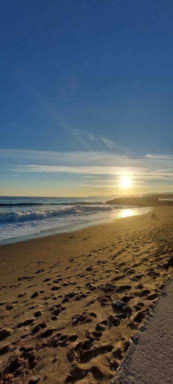 a beach with footprints in the sand and the ocean at Appartamento PANORAMA N 4 POSTI LETTO in Varazze