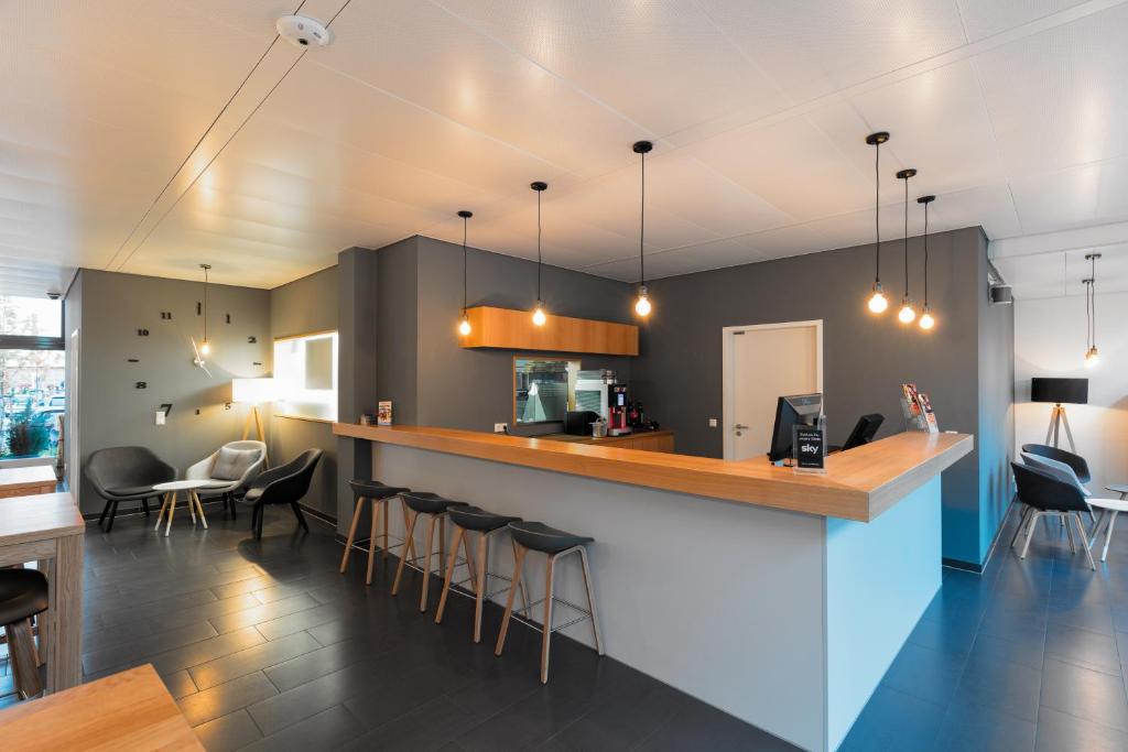 a kitchen and dining room with a bar with stools at mk hotel stuttgart in Stuttgart