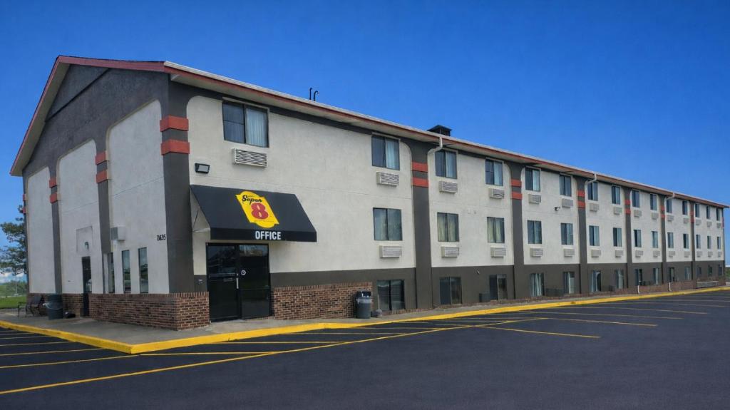 a large white building on the side of a street at Super 8 by Wyndham Lincoln West in Lincoln