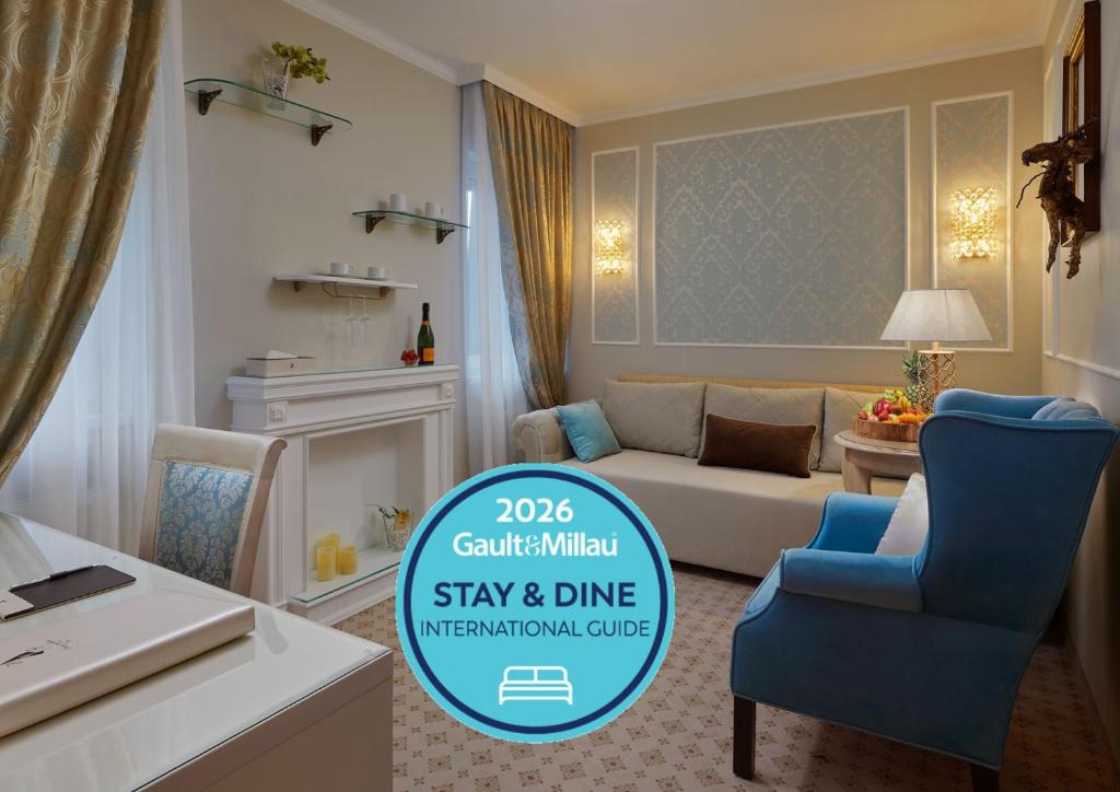 a room with a couch and a chair and a table at Honour and Grace Hotel in Jáchymov