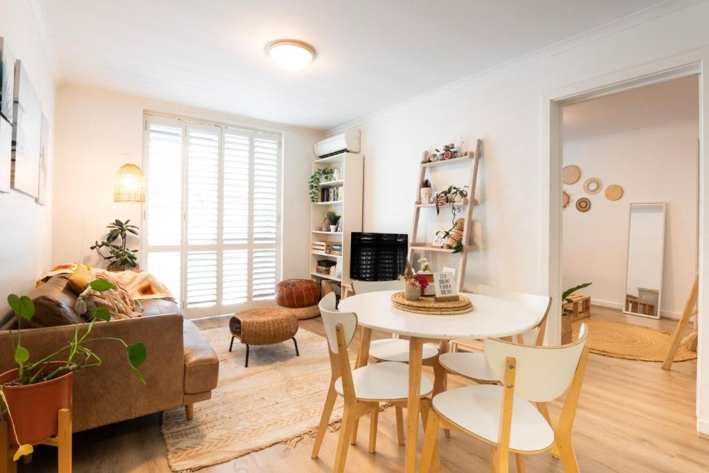a living room with a table and chairs at Boho by the Bay in Melbourne
