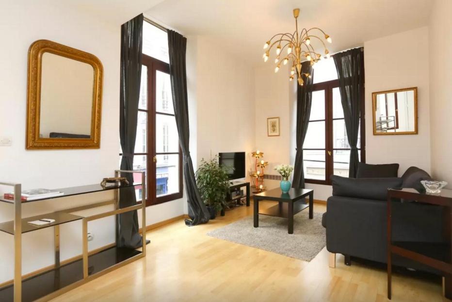 - un salon avec un canapé et un miroir dans l'établissement Apartment Paris 1° centre - Louvre, à Paris