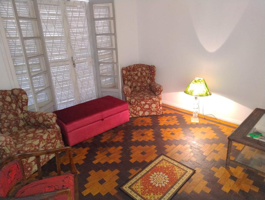 a living room with two chairs and a lamp at Pousada in Porto Alegre