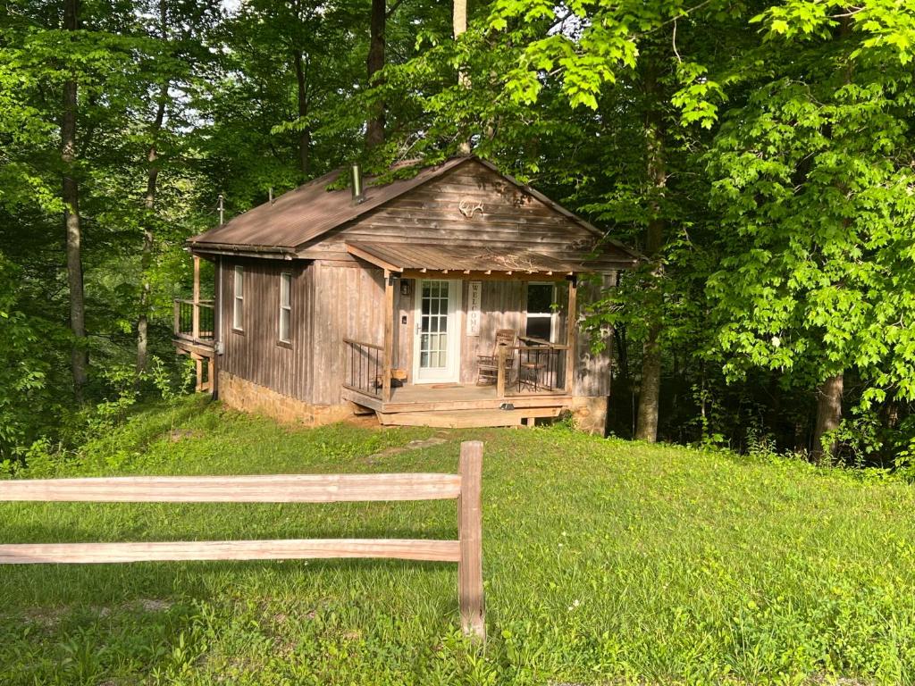a small shack in the middle of a field with a bench at Salt Creek Cabin in Chillicothe