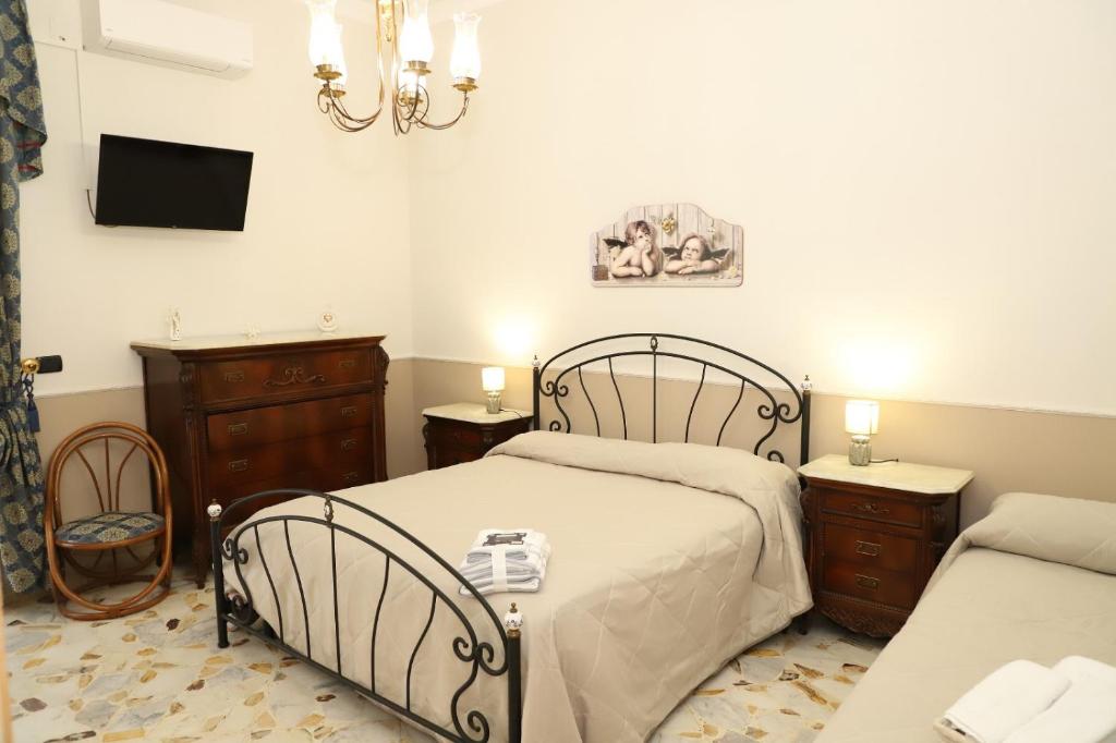 a bedroom with two beds and a tv at Paradiso dell'Etna in Zafferana Etnea