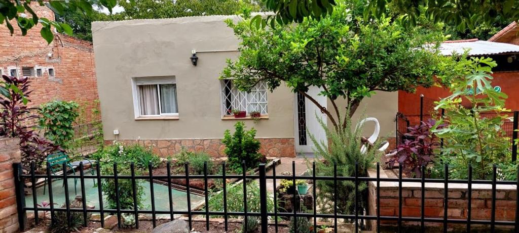 a house with a fence in front of a garden at Casa Uchita in La Falda