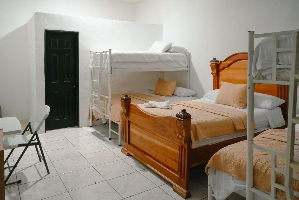 a bedroom with two bunk beds and a chair at Casa Belén in Flores
