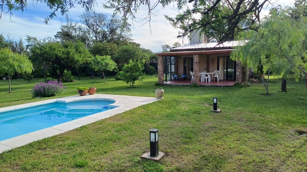 a cottage with a swimming pool in the yard at Las Guardia in Cortaderas