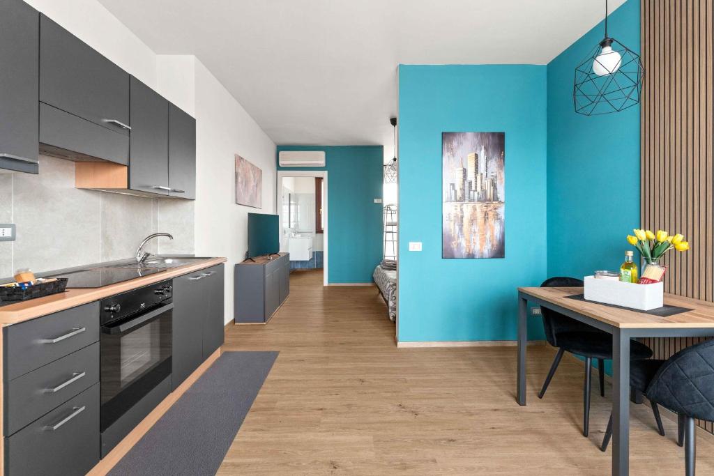 a kitchen with a table and a blue wall at CasaTella Rose in Suite in Rosate
