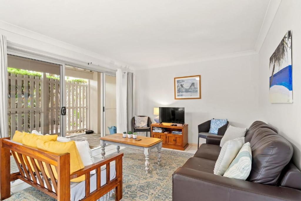 a living room with a couch and a table at At The Beach in Lennox Head