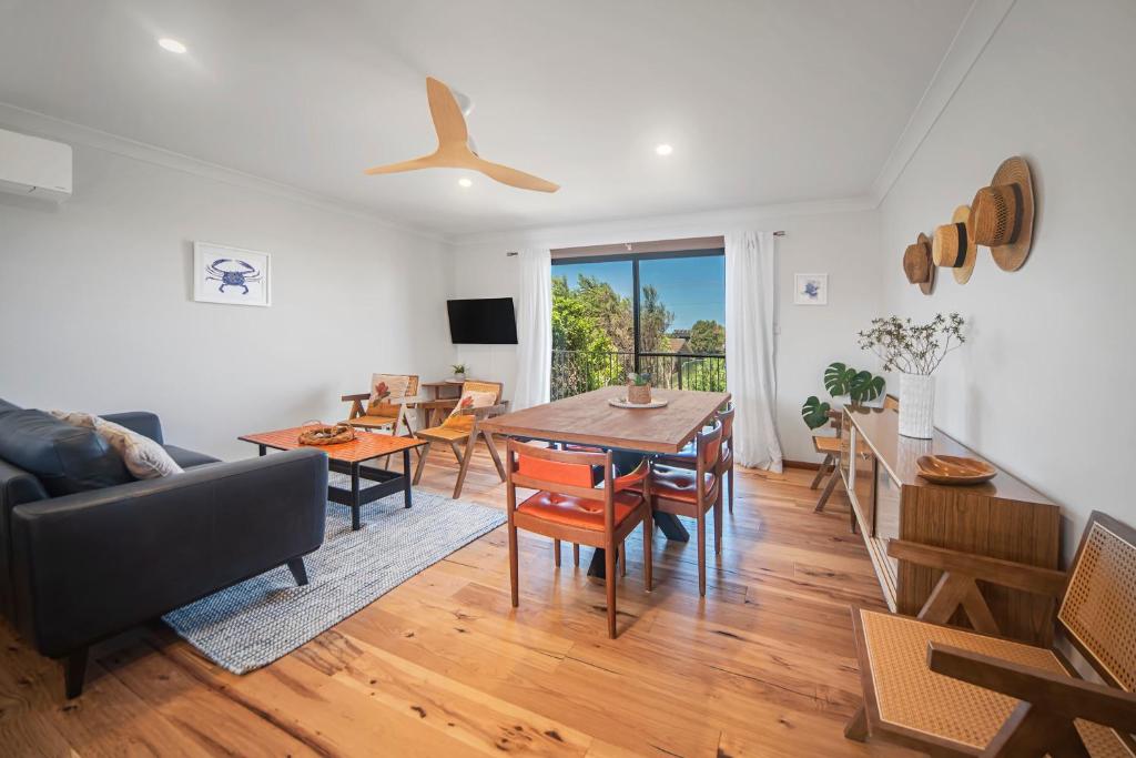 a living room with a table and a dining room at Sea Stroll at Callala Beach in Callala Beach