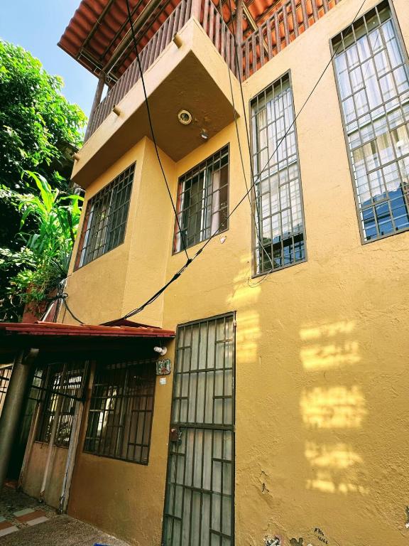 a yellow building with two doors and windows at Rent Casa La Moraleja in Ixtapa