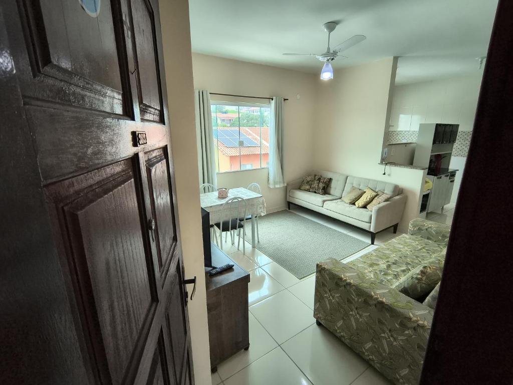 a living room with a couch and a table at Casa e Mar Apto aconchegante perto da praia com estacionamento in São Pedro da Aldeia