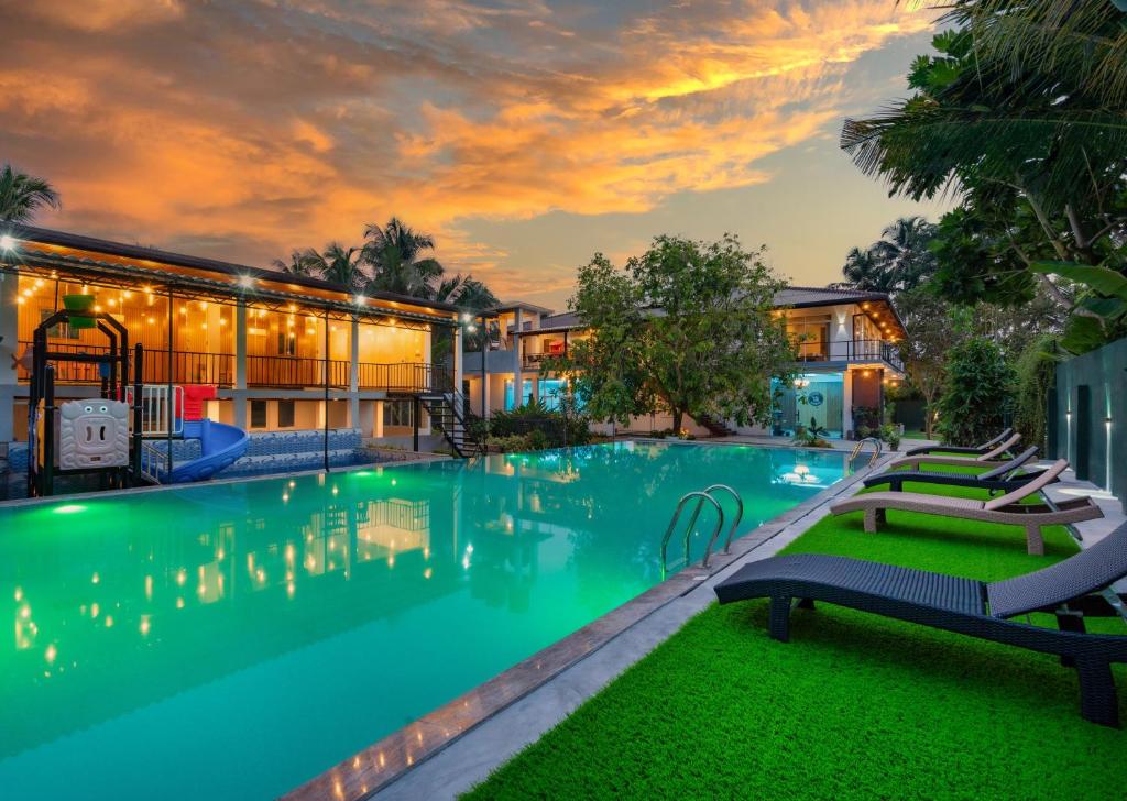 a large swimming pool with chairs in front of a building at Talpe Paradise in Galle