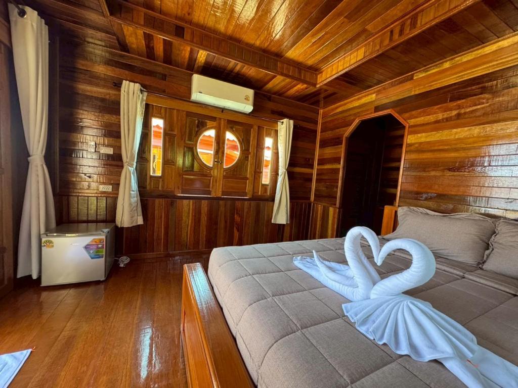 a bedroom with a bed with two white swans on it at Lamphu Resort Koh Lanta at Lanta Old Town in Ko Lanta