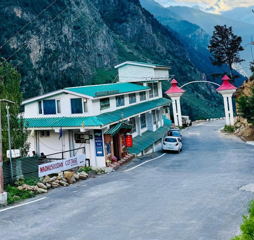 a car parked in front of a building on a street at Hotel Buro The Gate in Kalpa