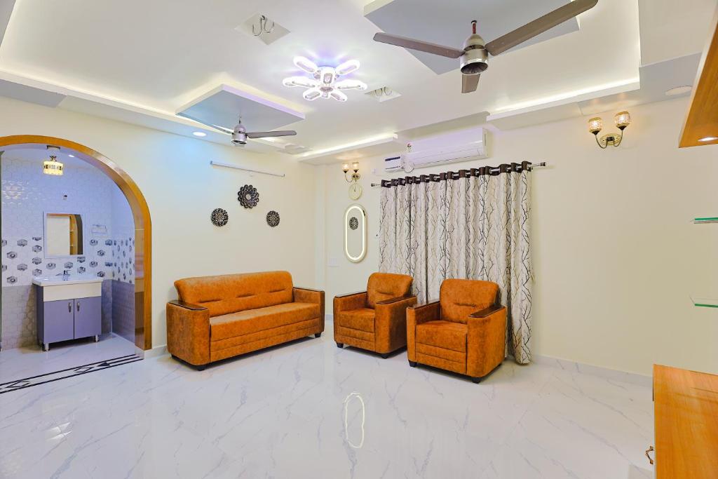 a living room with two chairs and a ceiling fan at Aashi-Premium Serviced Apartments in Chennai