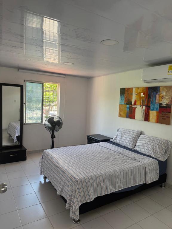 a bedroom with a bed and a window and a fan at Casa Cortijos in Valledupar