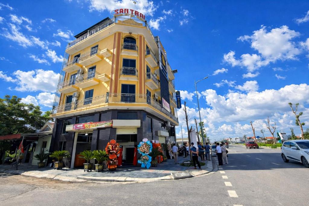 a yellow building with people standing in front of it at SanTran Hotel and Spa in Hai Phong