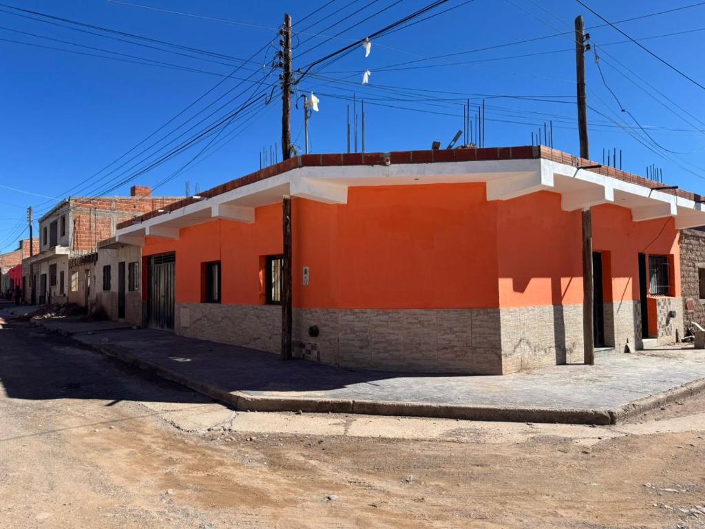 an orange and white building on the side of a street at Casa Alfonso 4 huéspedes y cochera gratis in Humahuaca