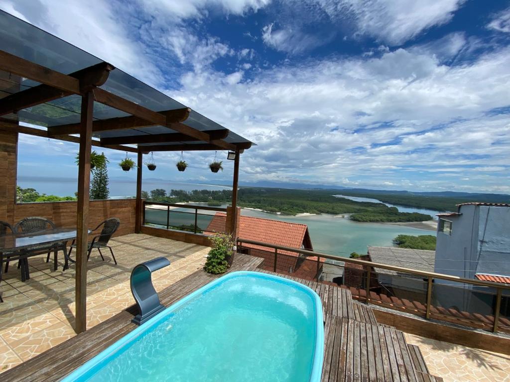 a pool on the deck of a house with a view at Cobertura luxuosa Marambaia in Barra de Guaratiba