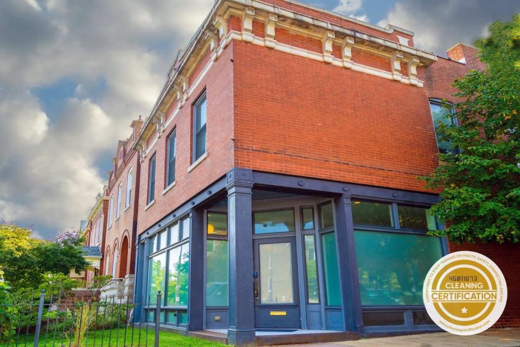 a brick building with a sign in front of it at Gorgeous 5BR Storefront Home ABODEbucks in Soulard