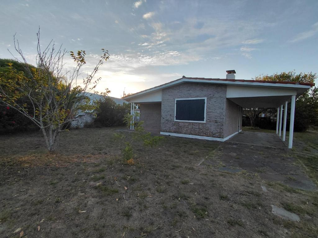 a small house with a window in a yard at Casa playera 2 dormitorios in La Paloma