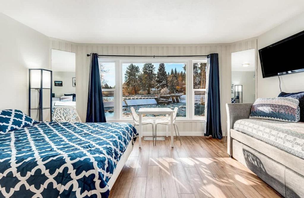 a bedroom with a bed and a view of a patio at Riverside Cottage - Just Steps from the Deschutes in Bend