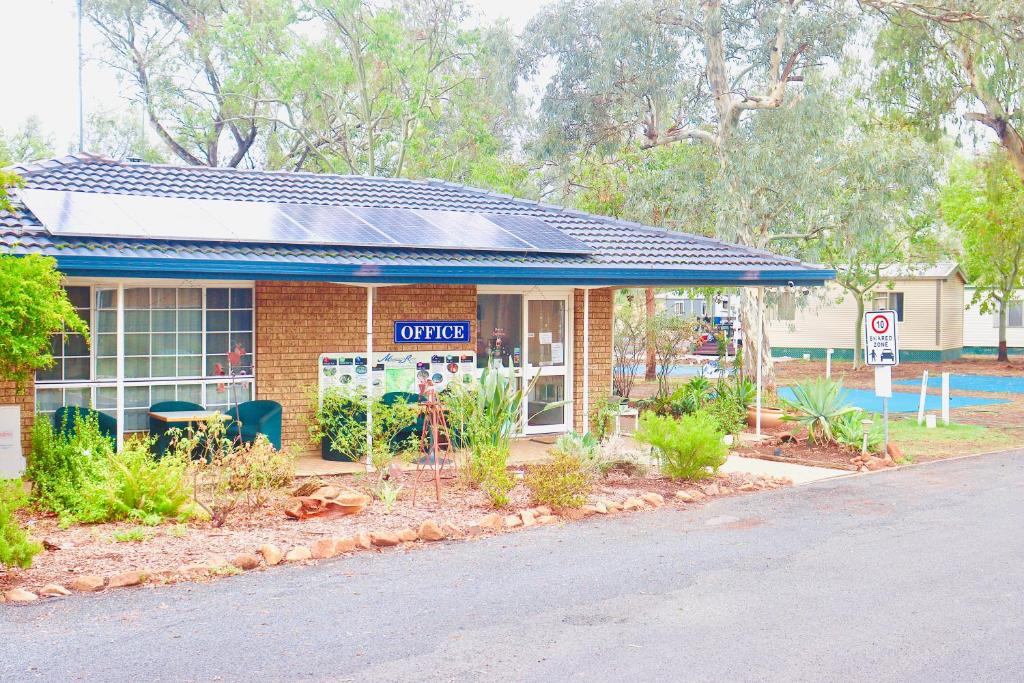 a brick building with a sign in front of it at Macquarie Caravan Park in Warren