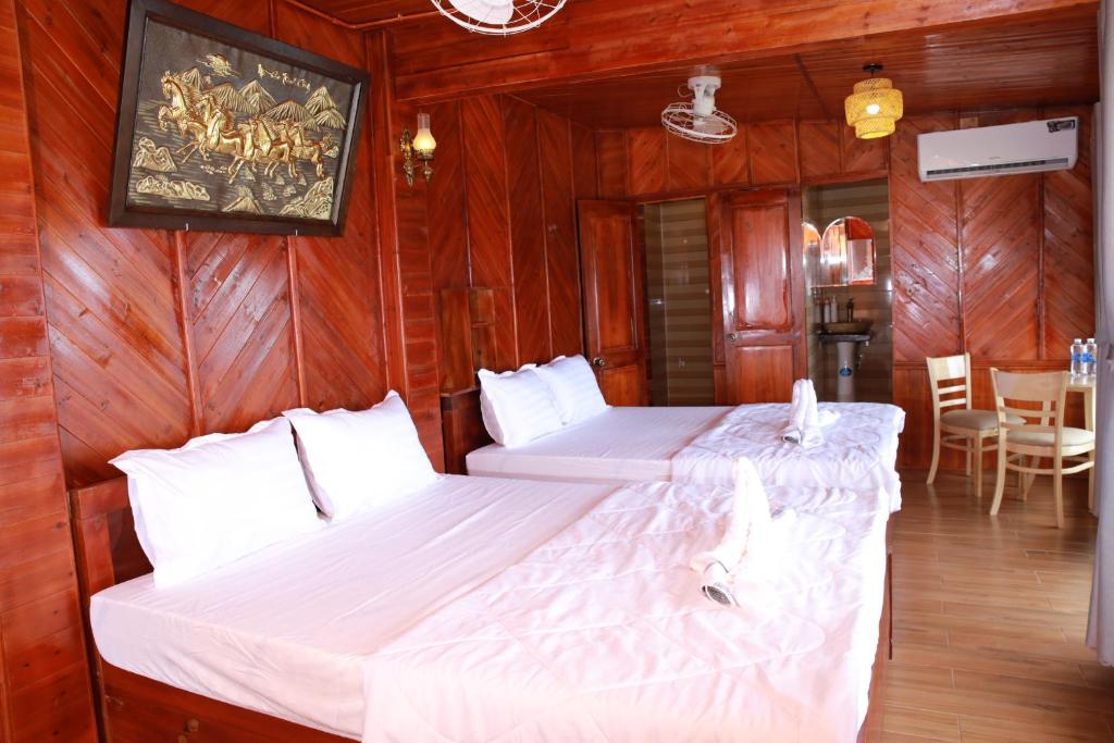 two beds in a room with wood paneling at Bungalow Hải Yến in Ly Son
