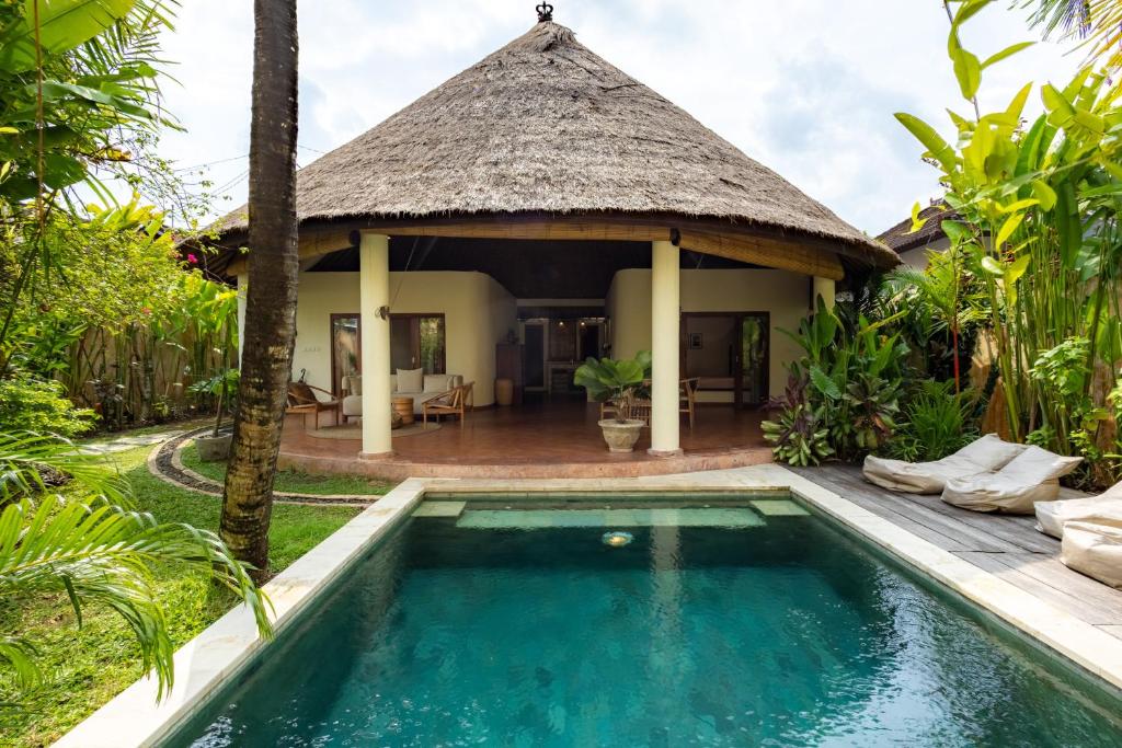 a villa with a swimming pool and a hut at Flor Villa by Betterplace in Dalung