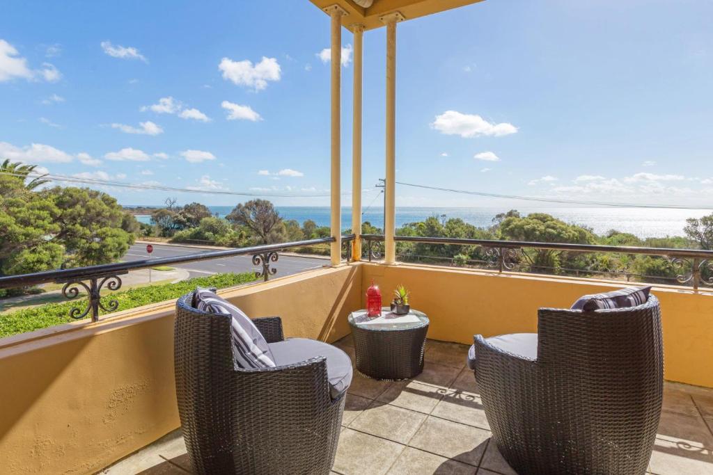 a balcony with chairs and a view of the ocean at Beach Belle Mornington in Mornington