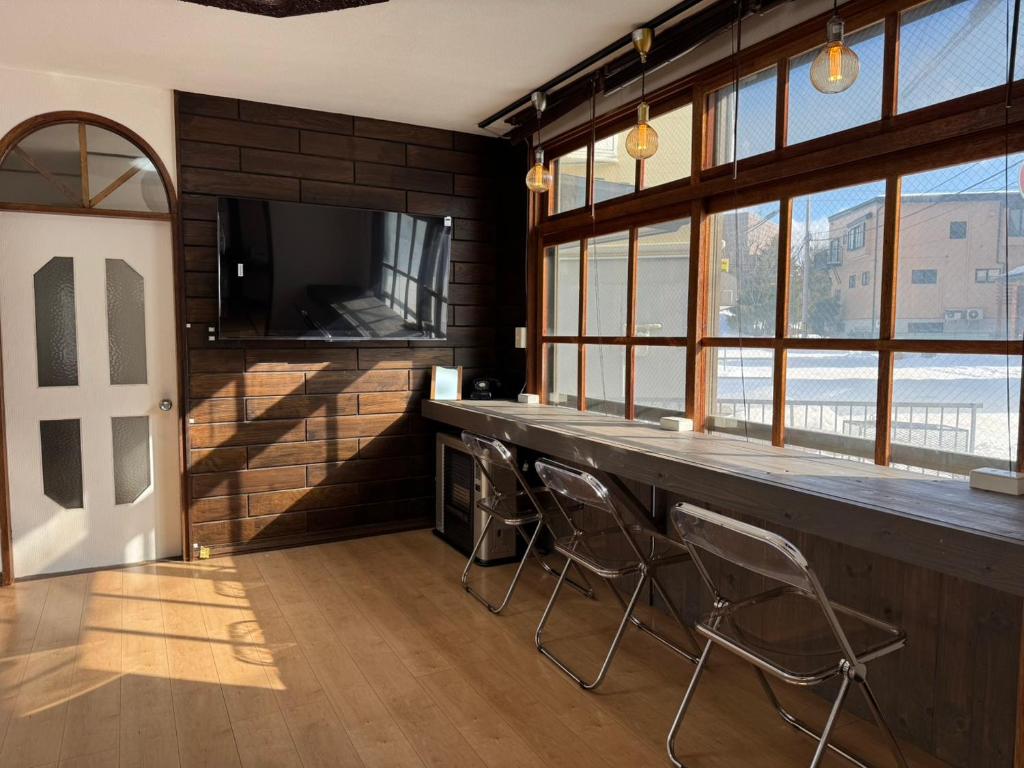 a bar with stools in a room with windows at Goryokaku rental house SAKURA in Hakodate