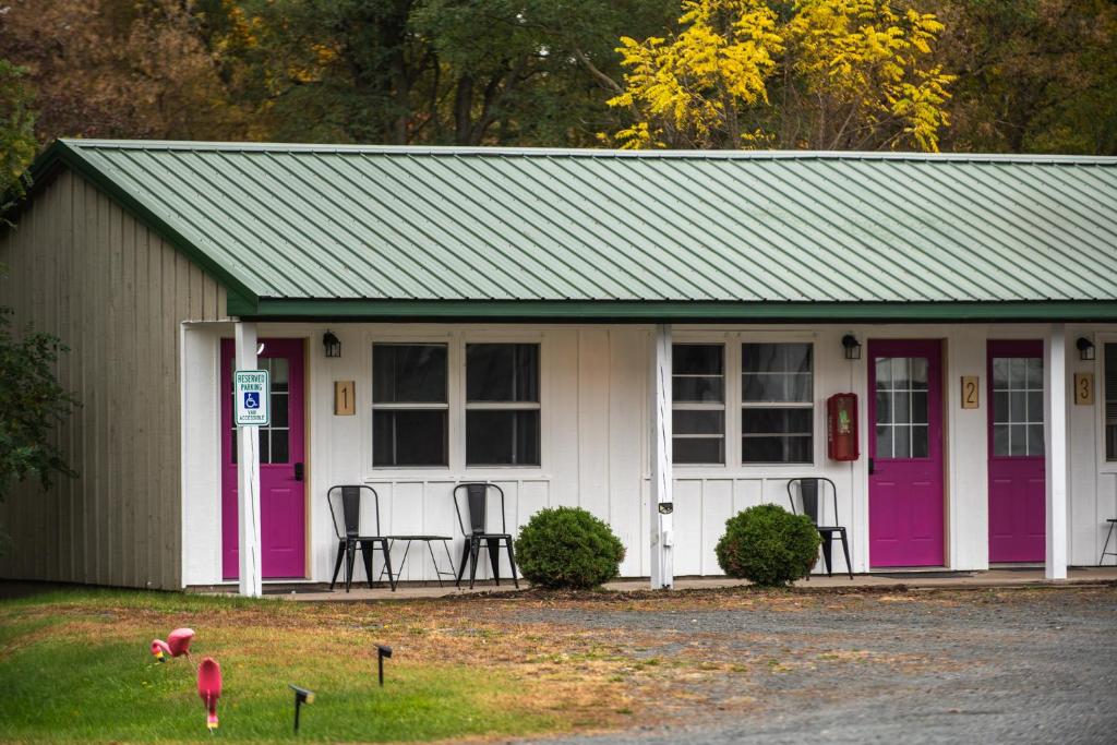 a small house with purple doors and chairs in it at Lumber Jill Lodge in Balsam Lake