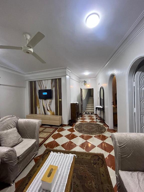 a living room with a couch and a tv at Dahabiya Apartment in Luxor
