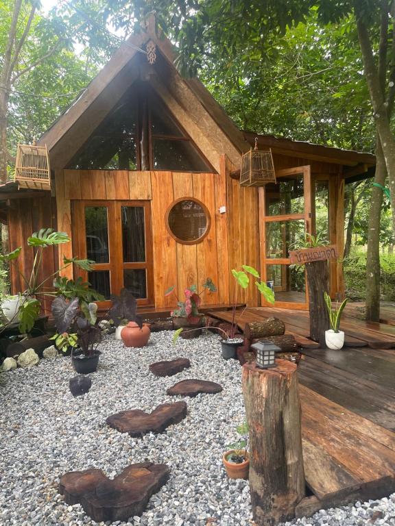 a small wooden cabin with plants in front of it at Baancherda in Ban Nong Hu
