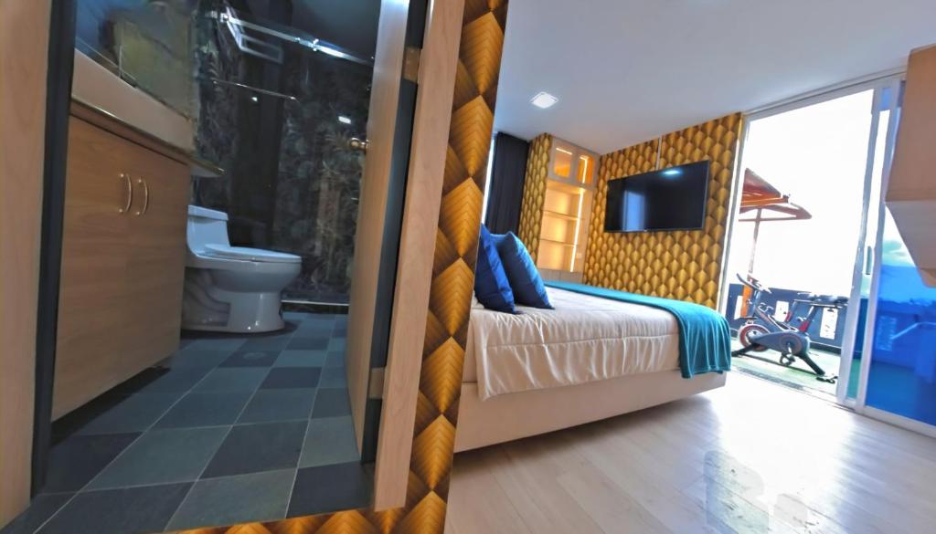 a bedroom with a bed and a tv and a bathroom at El Camino De Diego in Otavalo