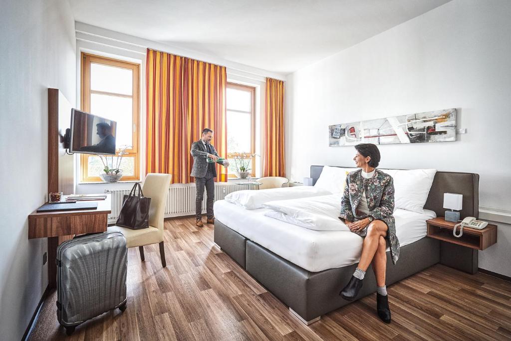 Eine Frau auf einem Bett in einem Hotelzimmer in der Unterkunft Health Vital Comfort Guestrooms in Wels