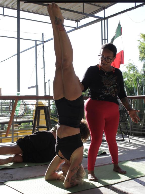 a woman standing next to a woman doing a yoga pose at Mantra Homestay in Bacalar