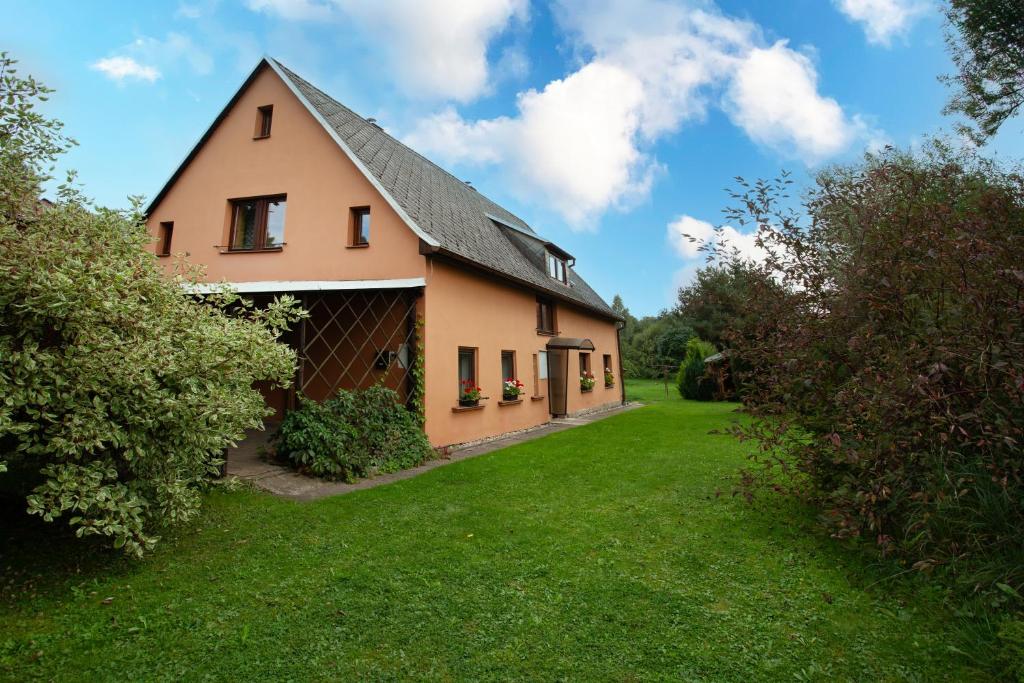 a house with a gambrel roof on a green yard at Chalupa u Bruna in Ruprechtice