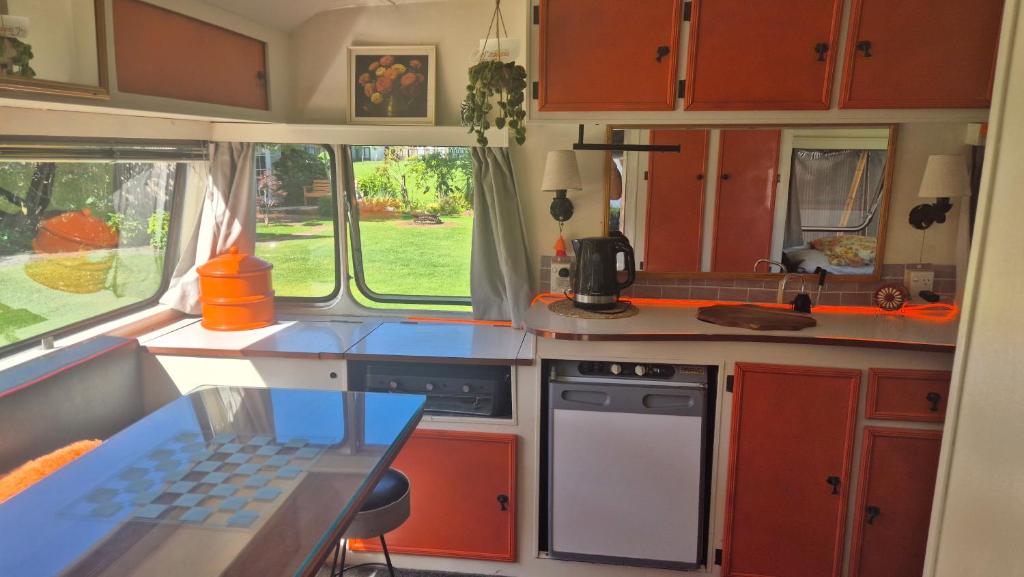 a kitchen in an rv with a table in it at Boutique Retro Caravan in Westport