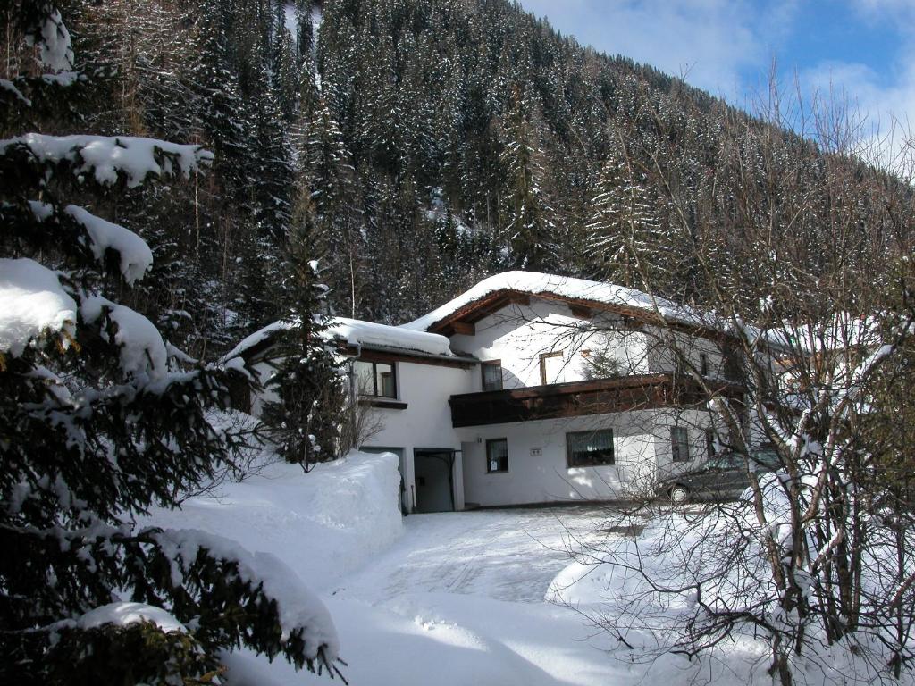 een huis bedekt met sneeuw voor een berg bij Appartements Max&Moritz in Kaunertal
