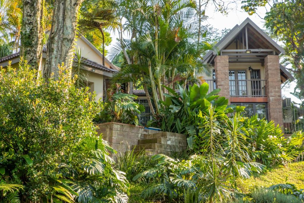 a house with trees and plants in front of it at Black n Whyt Villa in Kloof