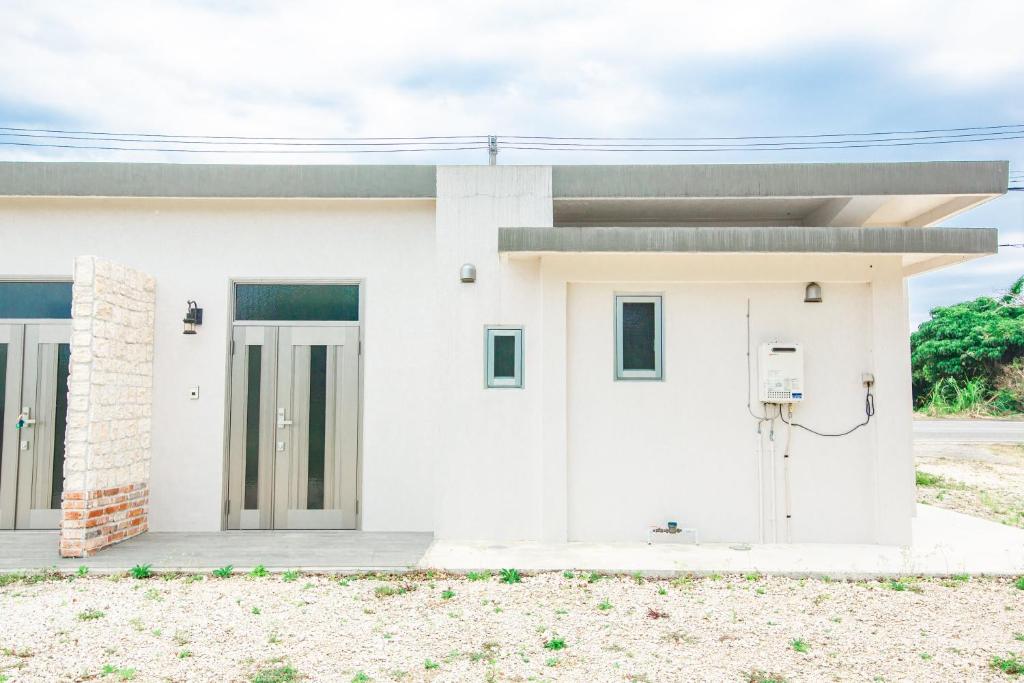 a white house with two doors at がじゅまる Miyako Hotel in Miyakojima