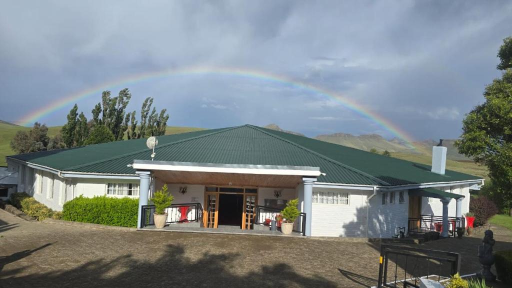 a rainbow over a house with at Mountain Shadows Hotel in Barkly East