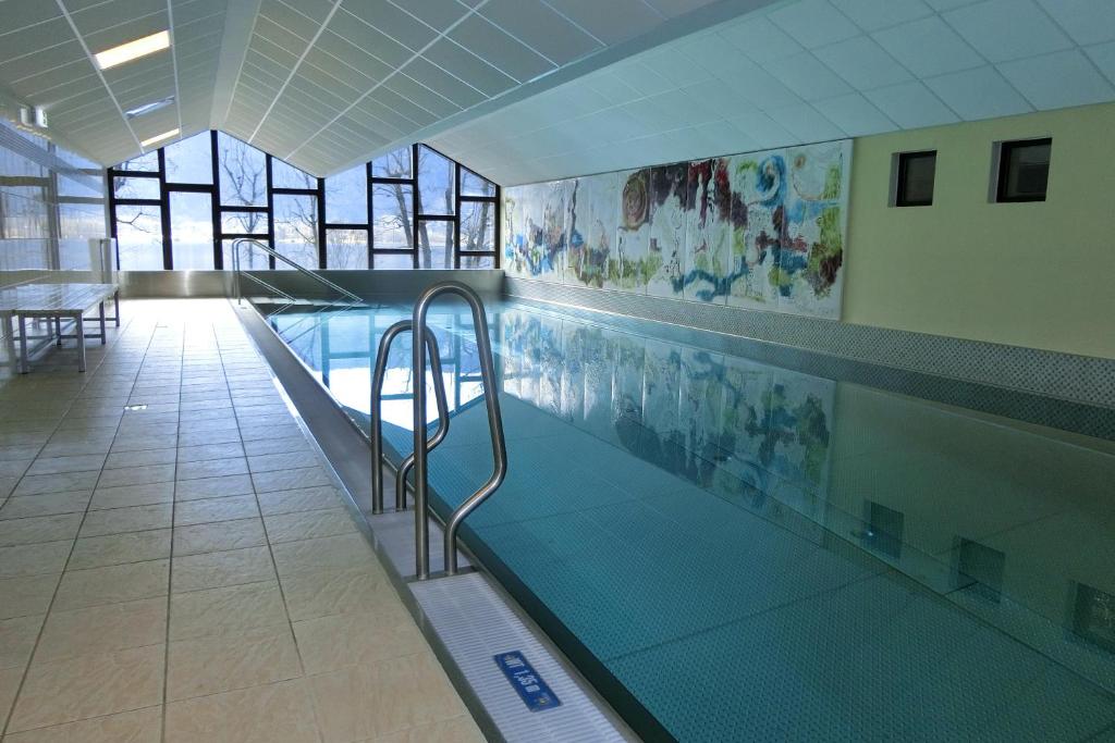 a swimming pool in a building with a swimming pool at ANNA Seeblick Appartement, Haus Hänsel&Gretel am Ossiachersee, Hallenbad, Skiarena Gerlitzen in Bodensdorf