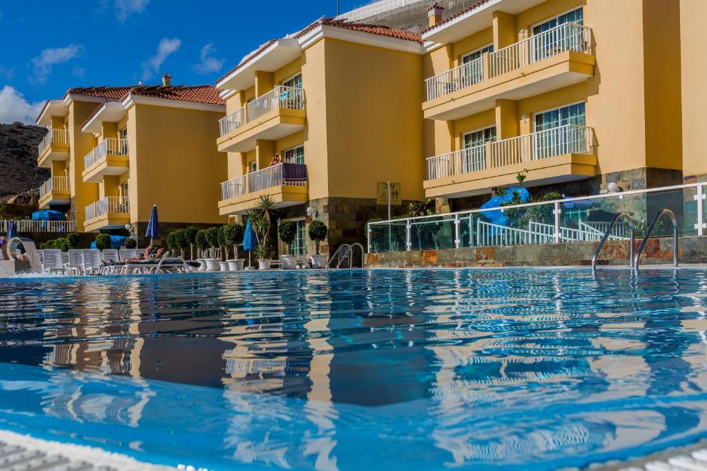 a swimming pool in front of a resort at Villa del Mar in Patalavaca